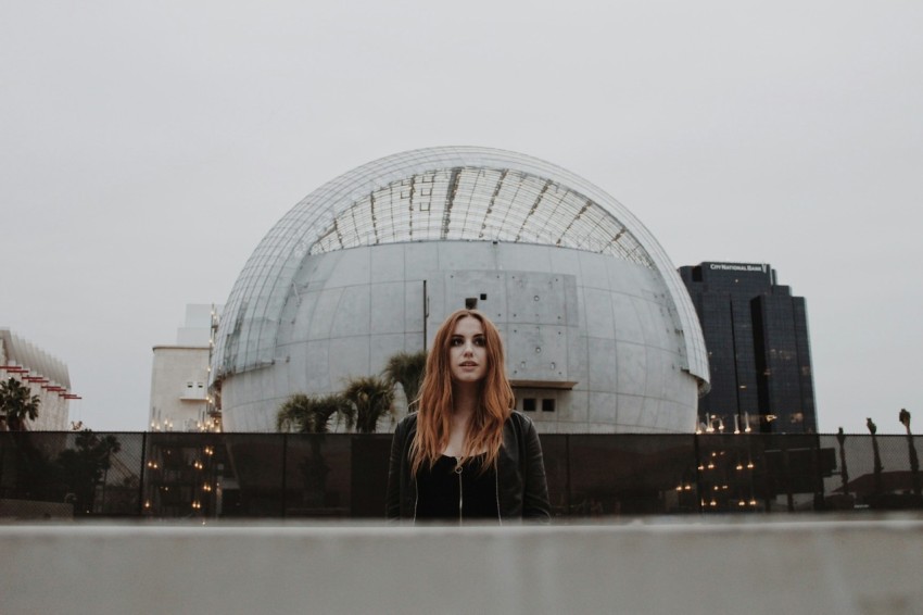 woman in black long sleeve shirt standing near glass building during daytime