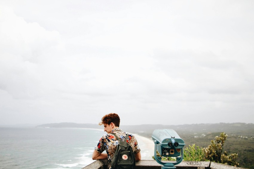 man in black and white floral shirt sitting on blue and black motorcycle looking at the on on on on HLd