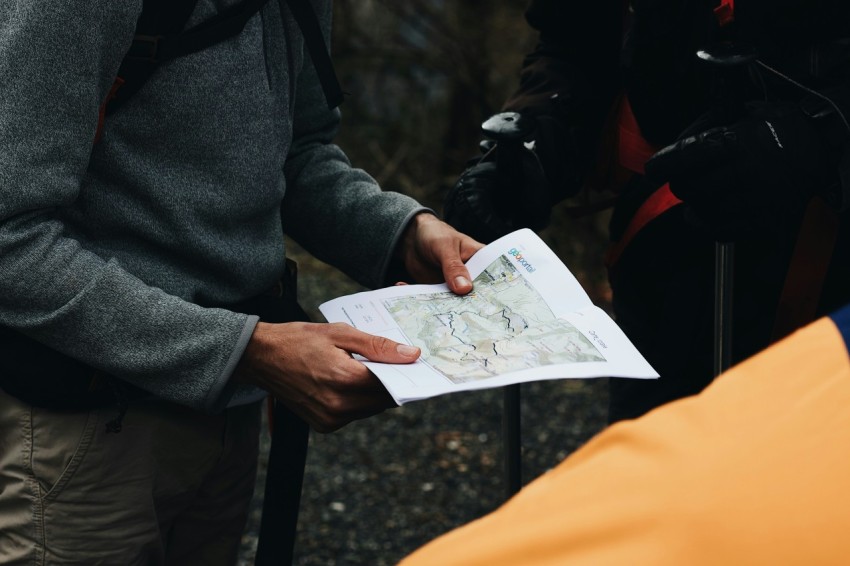 person in gray coat holding white printer paper