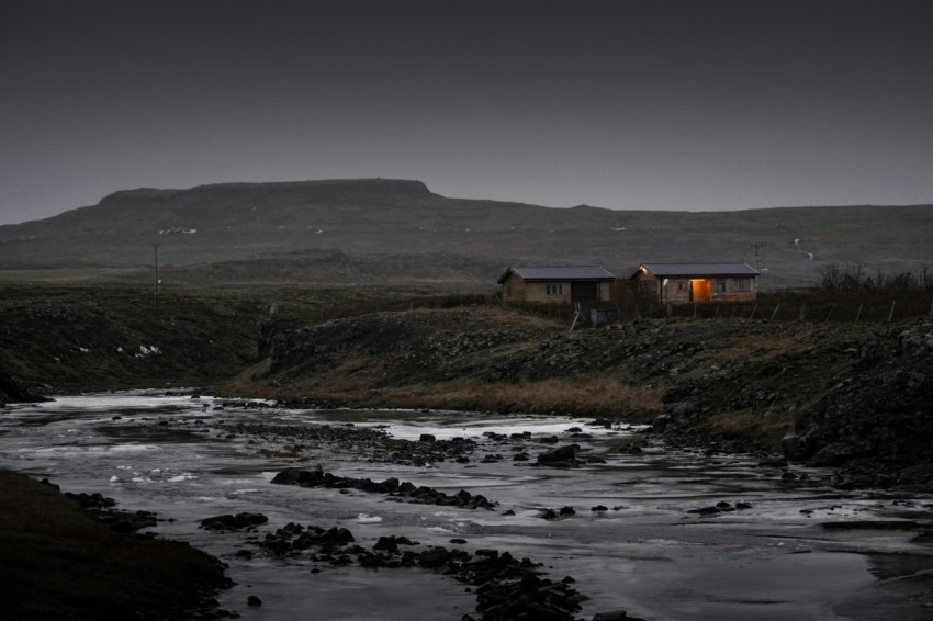 brown house near body of water during daytime