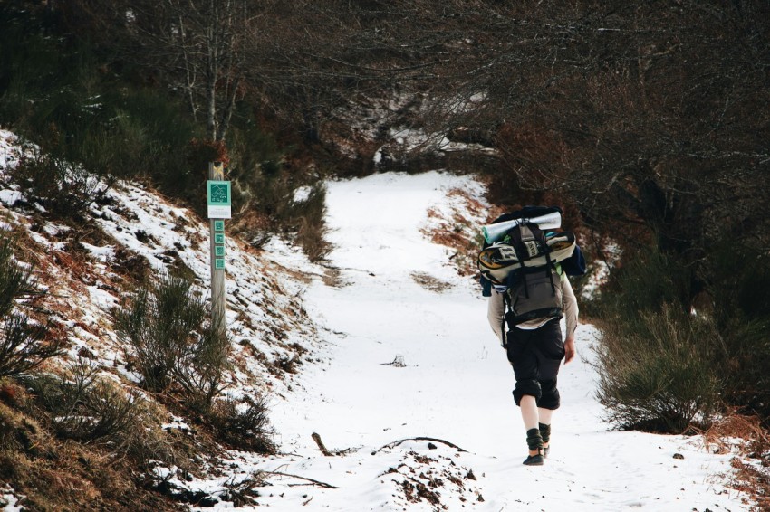 person in black jacket and black pants walking on snow covered ground during daytime r4bS