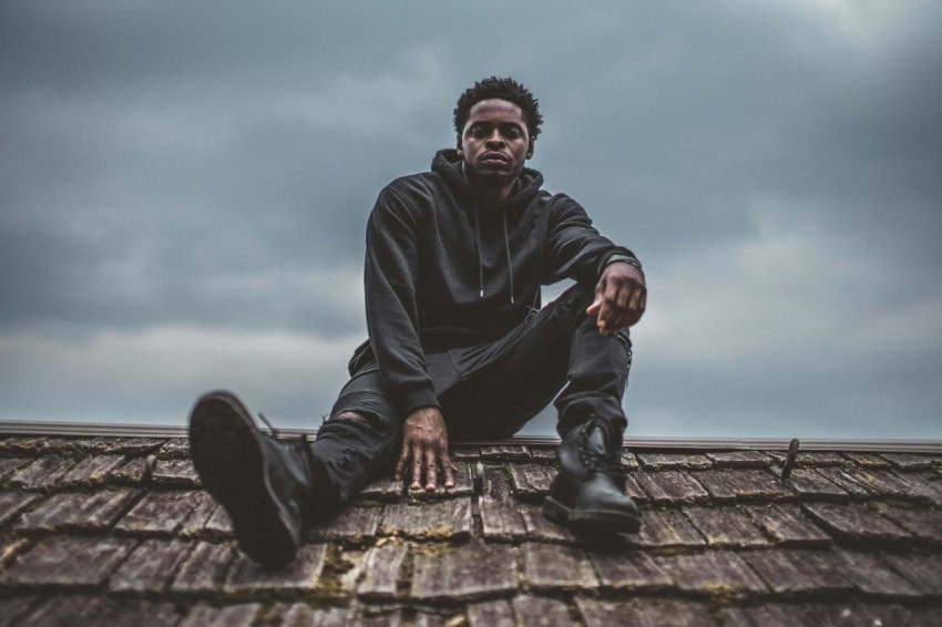 man in black pullover hoodie sitting on roof