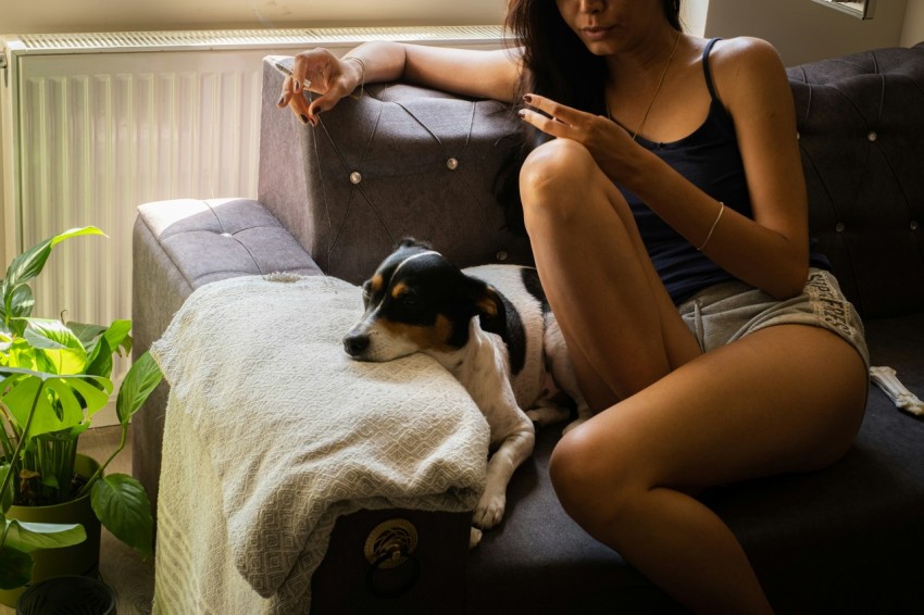 a woman sitting on a couch with a dog