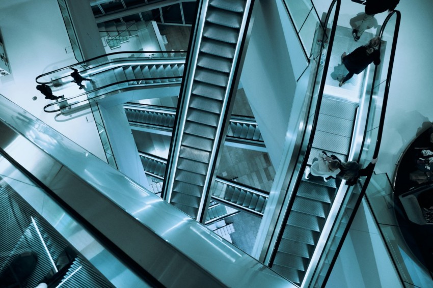 people walking on escalator inside building