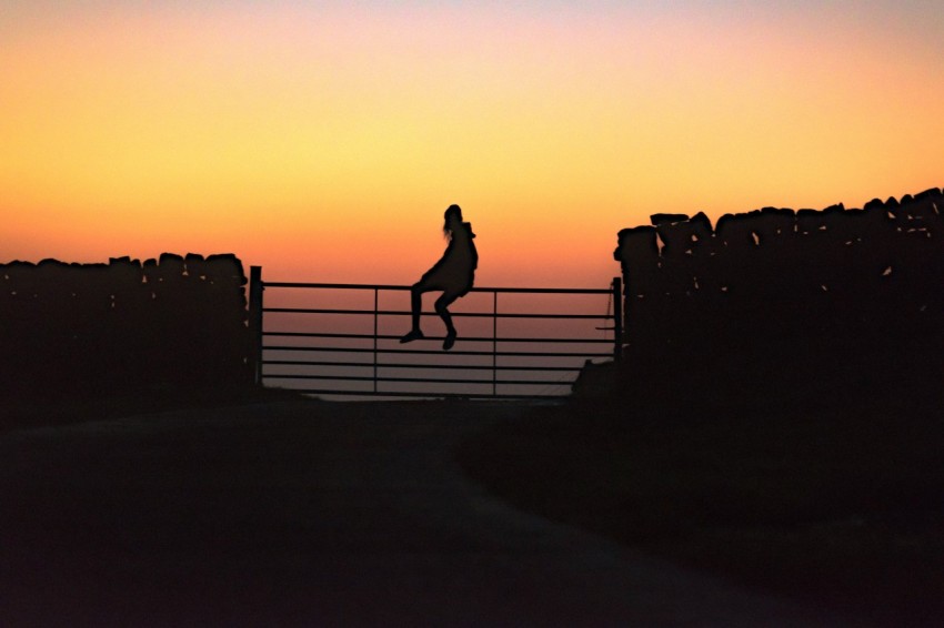 woman sitting on fence