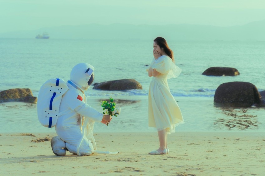 a person standing next to two people in clothing on a beach