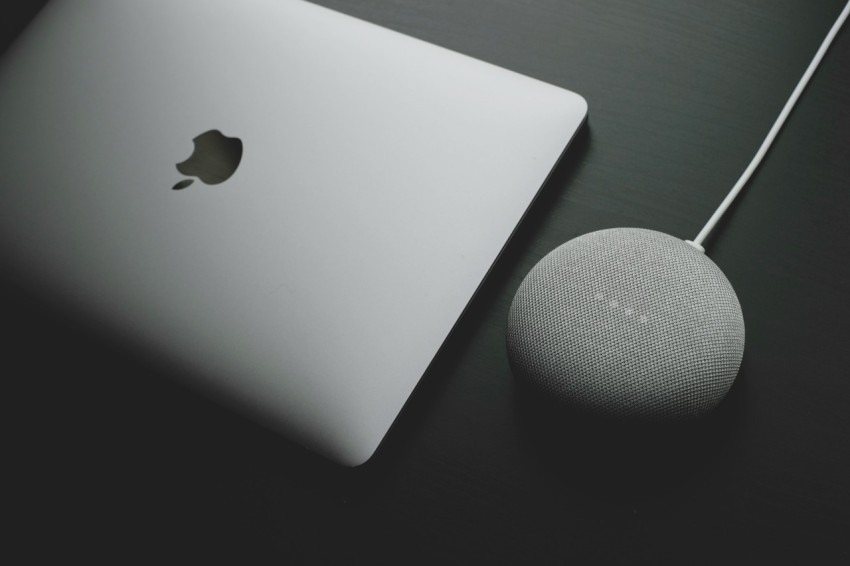 silver macbook on black table