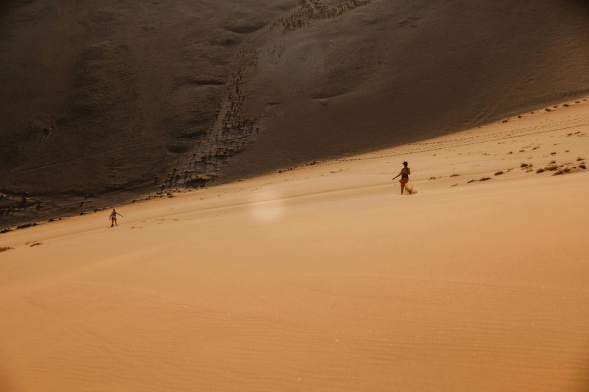 people walking on desert sand during daytime