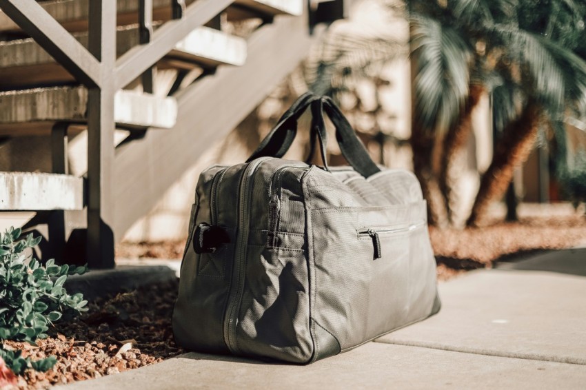 gray leather backpack on white concrete floor