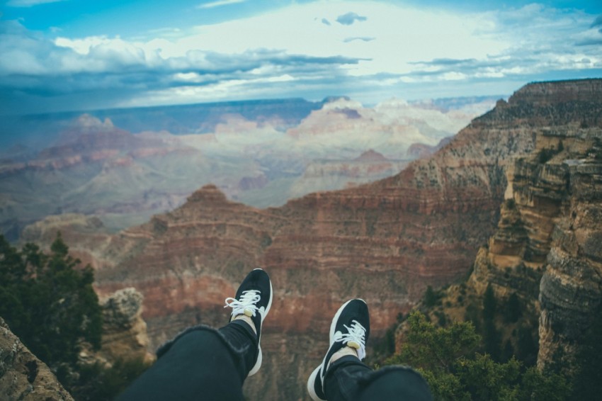 person sitting looking through mountain taken under white clouds during daytime 8aLhR44