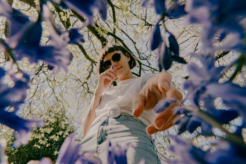 woman in white dress under white flower tree during daytime