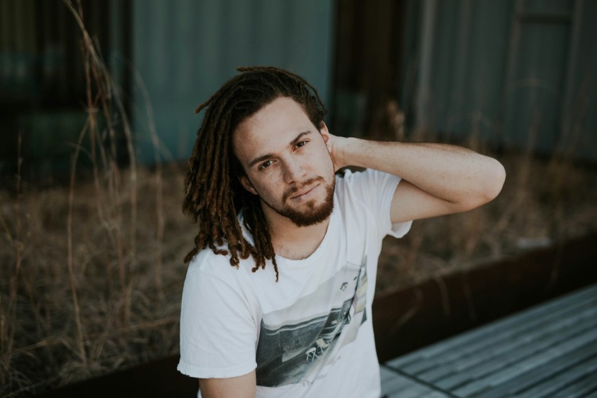 man in white scoop neck shirt sitting on gray bench