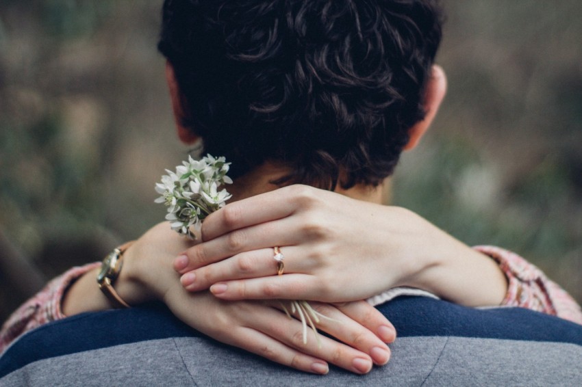 womans hand on mans shoulder in close up photo