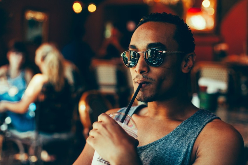 man sipping cooler while sitting on chair c