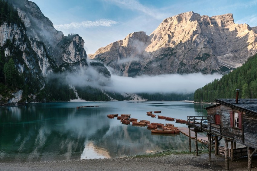 a lake with a house and mountains in the background