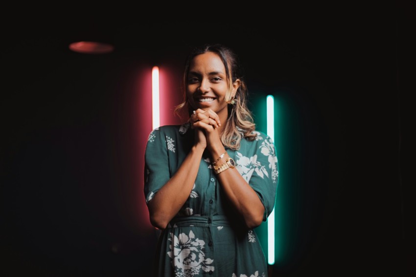 a woman standing in front of a neon light