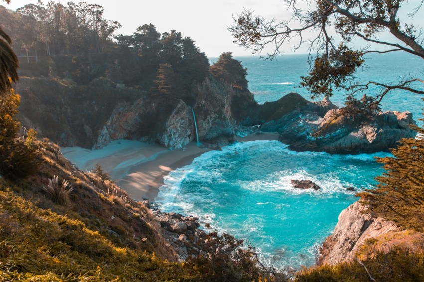 body of water near trees and mountain cliff during daytime TWoL