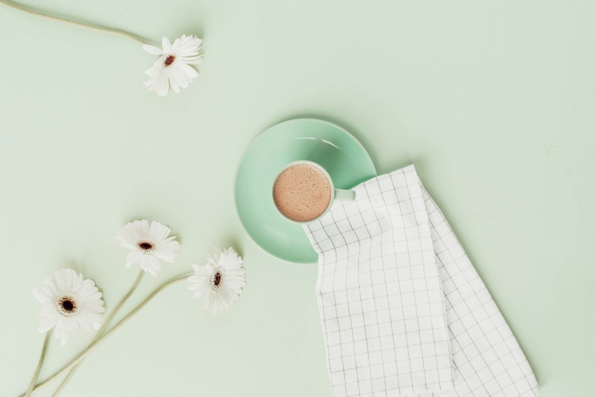 cup of beverage with daisies