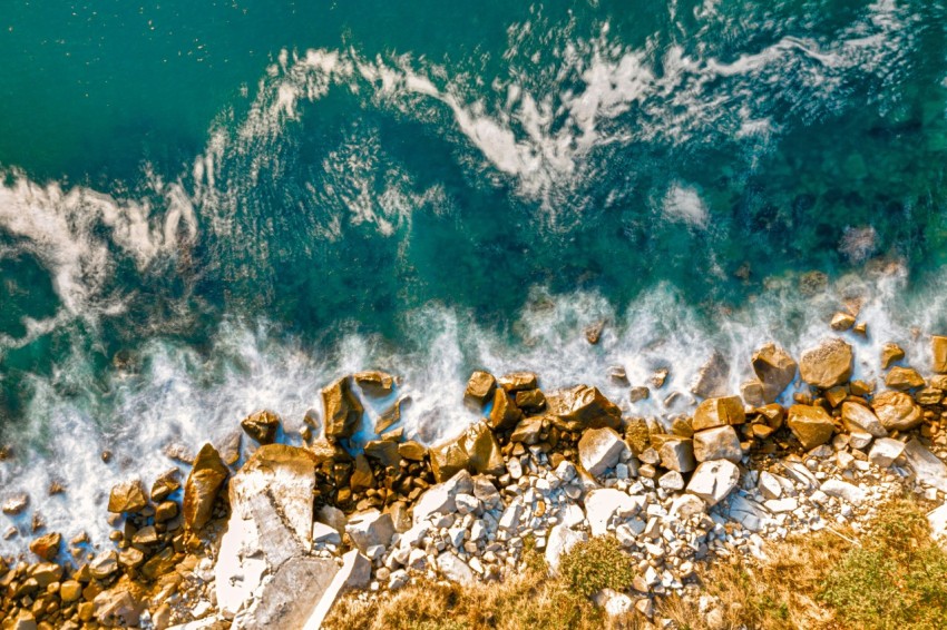 brown rocks on blue body of water during daytime