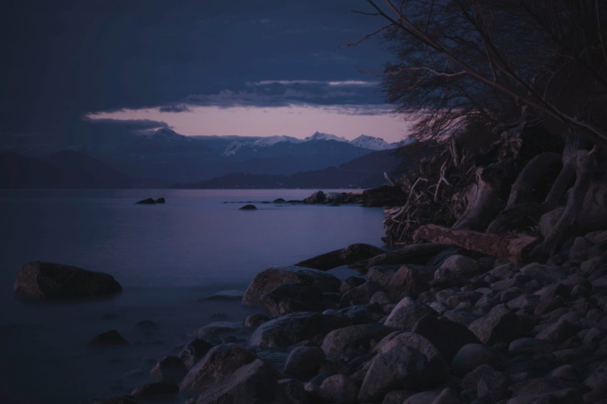 grey rock near body of water during dawn