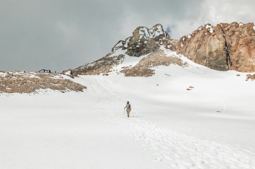 a person walking across a snow covered mountain