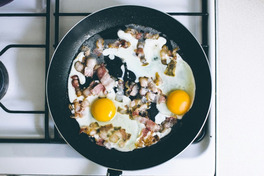 two fried eggs with meat on frying pan