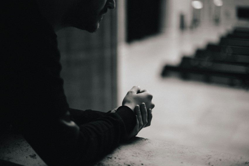 a black and white photo of a person sitting at a table