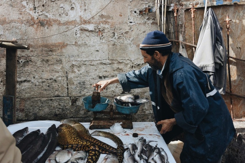 man front of fish on table