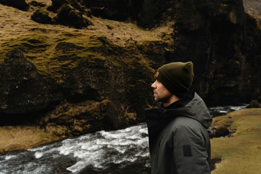 a man standing next to a river