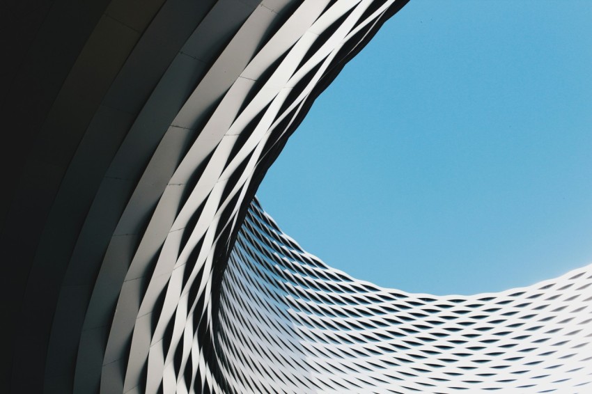 grey curved concrete structure under blue sky during daytime od