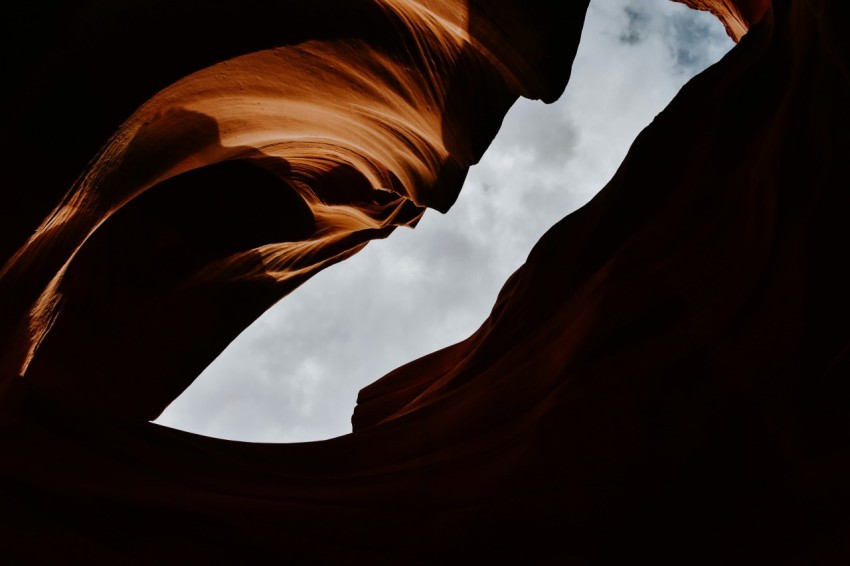 a view of the sky through a window in a rock formation