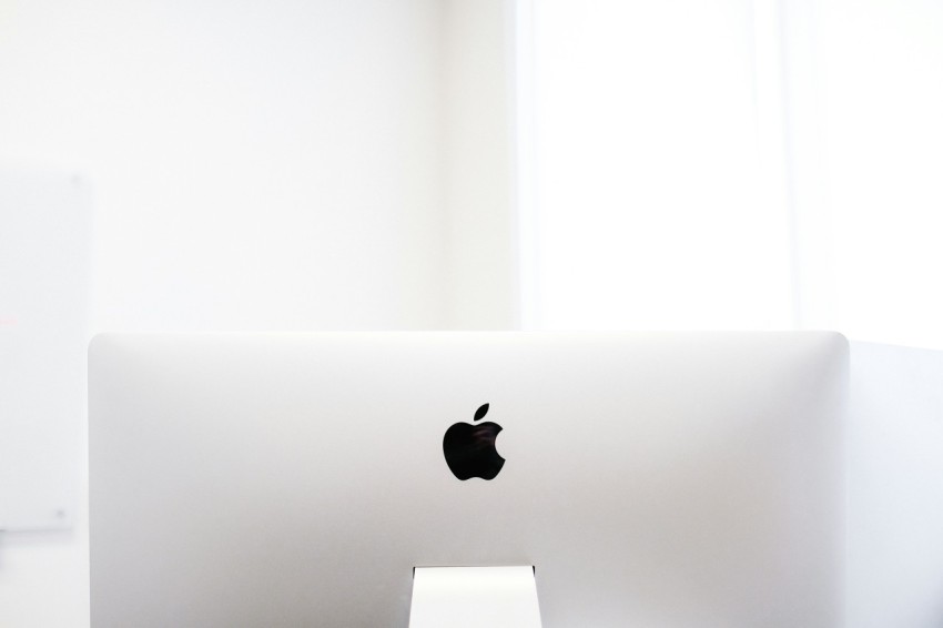 silver macbook on brown wooden table