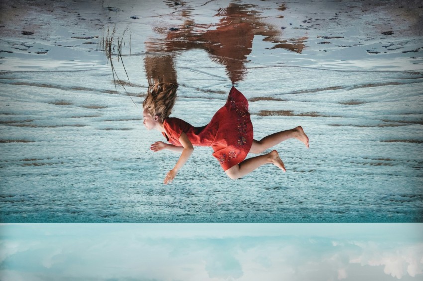 a woman in a red dress is floating in the water