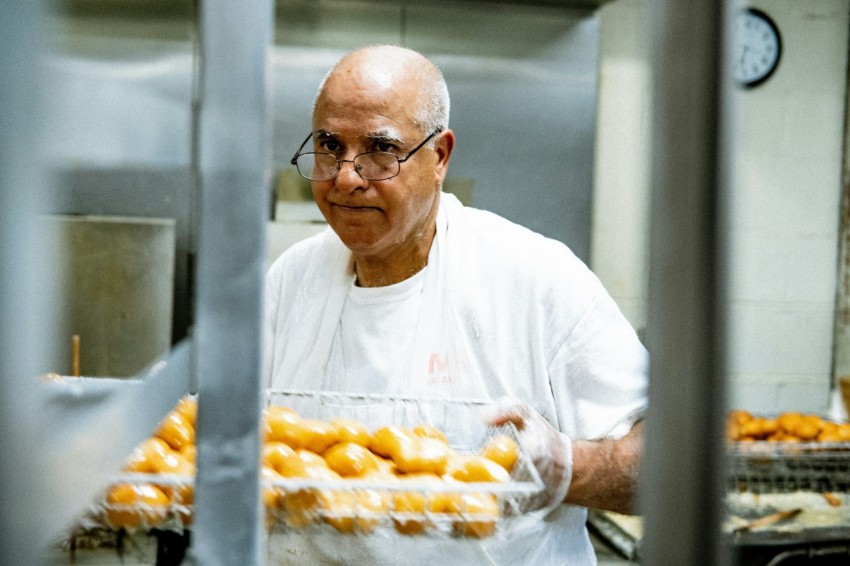 man in white crew neck t shirt holding tray of orange fruits