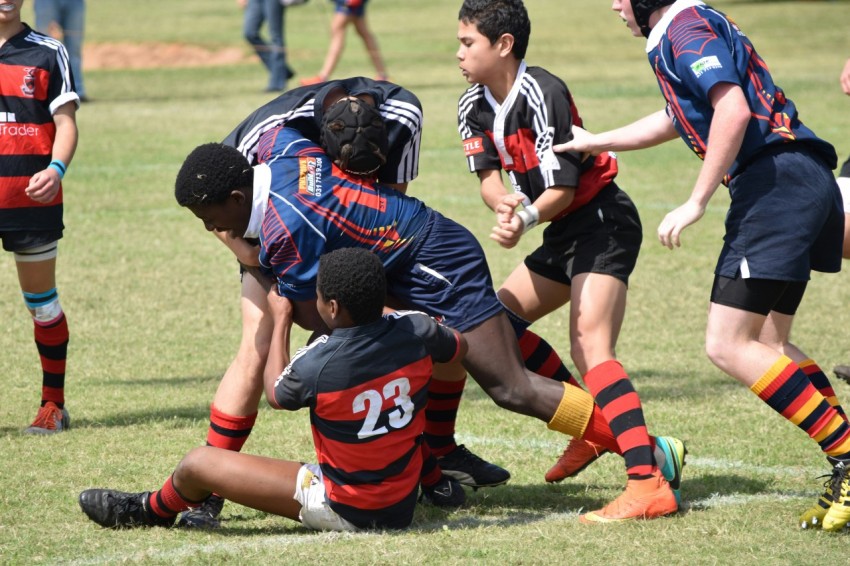 2 men in black and red jersey shirt playing soccer during daytime