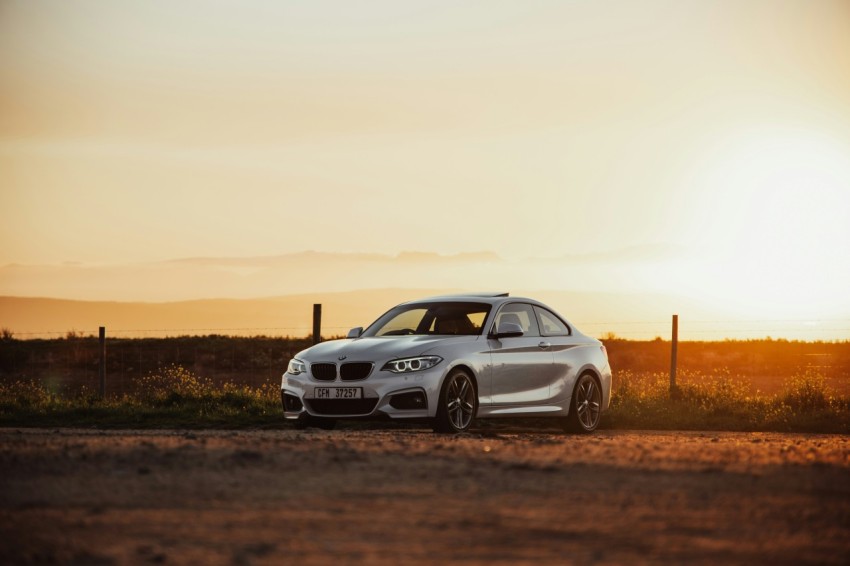 white bmw m 3 coupe on brown field during daytime