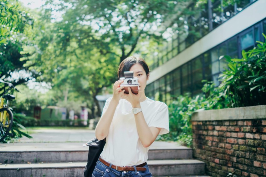 woman in white t shirt using camera frpCC