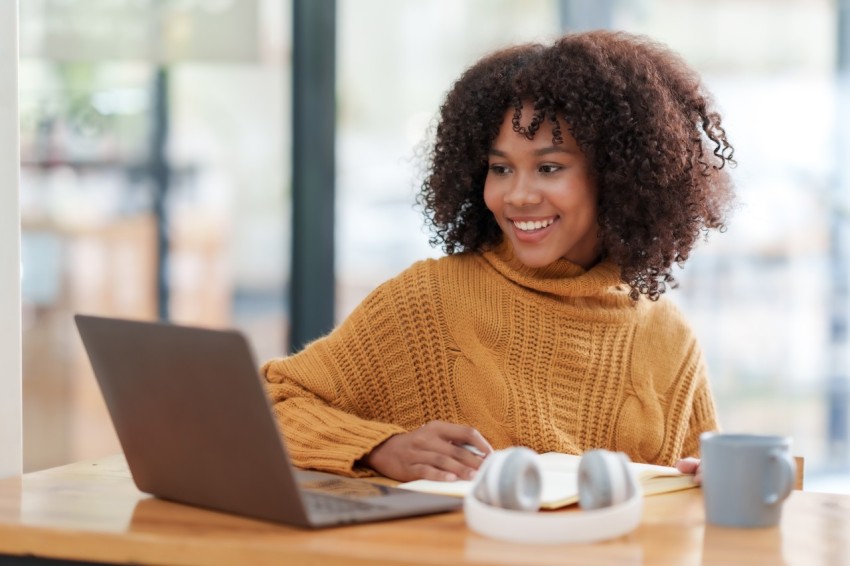 Lady with a smile in front of a laptop