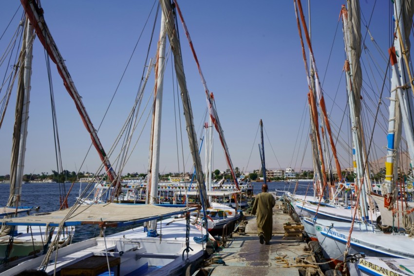 a man walking down a dock next to a bunch of boats