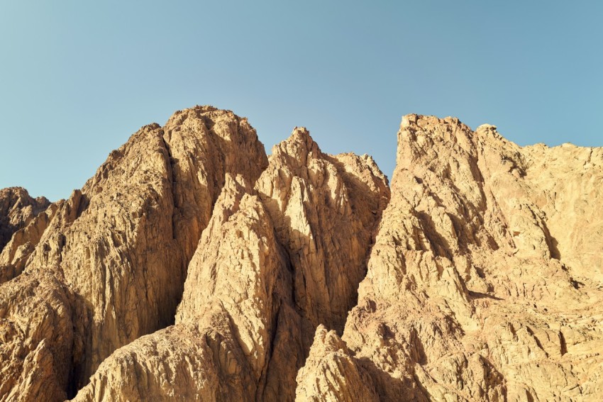 a rocky mountain with a blue sky