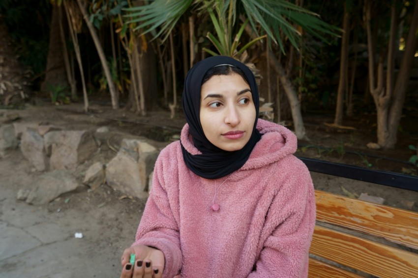 woman in purple hijab and pink sweater