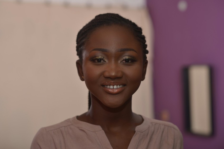 a woman with braids smiling at the camera