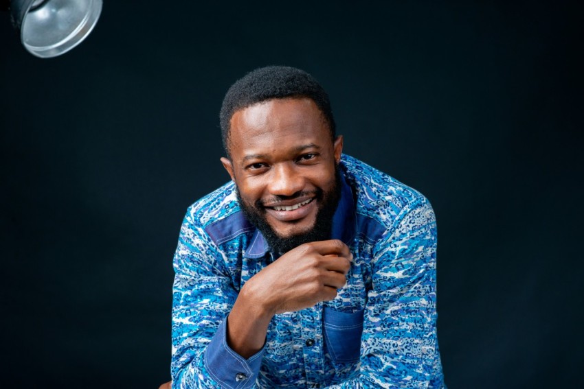 a man in a blue shirt posing for a picture