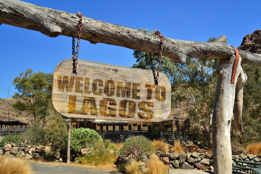 a wooden sign hanging from a wooden fence