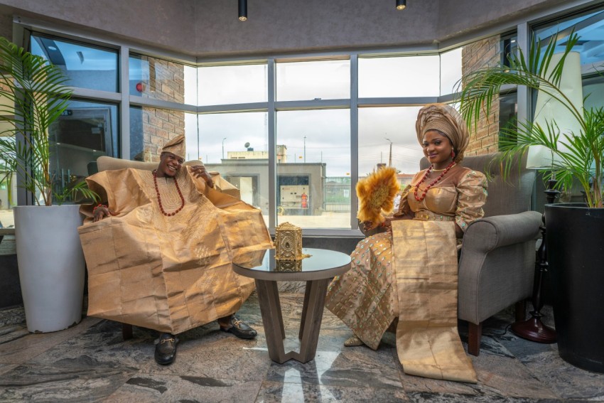 a couple  sitting on a couch in a room with a large window