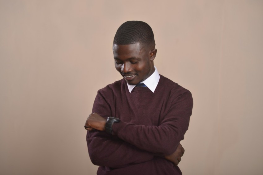 a man in a maroon sweater is looking at his cell phone