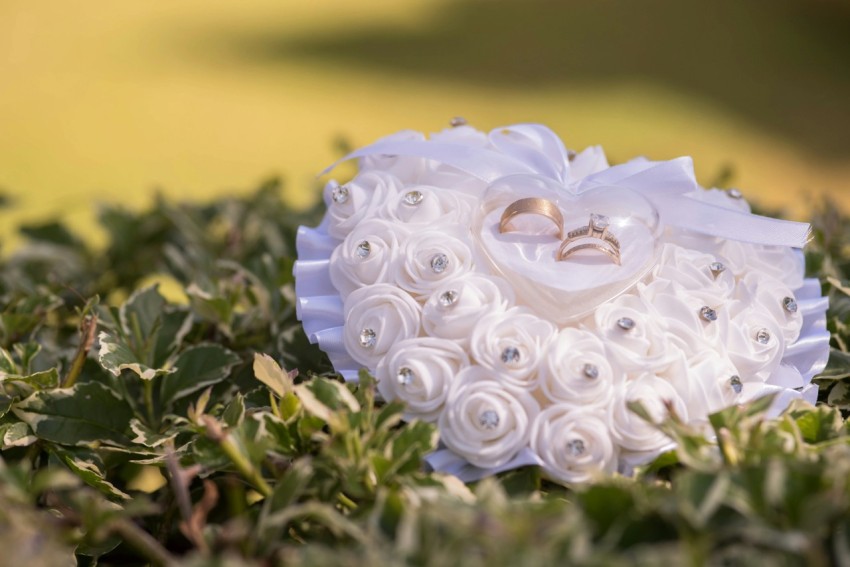 a bouquet of flowers and a wedding ring sits in the grass