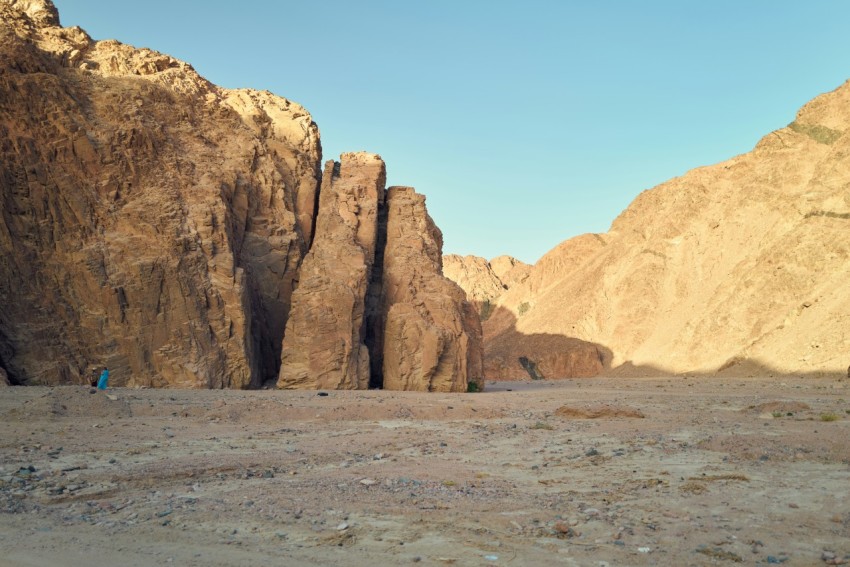 a person standing in a desert with valley of the queens in the background