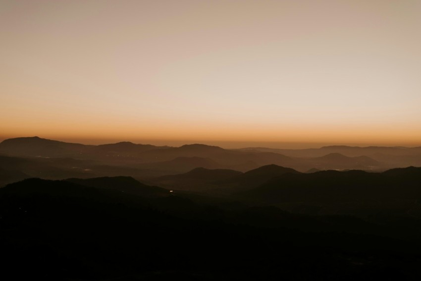 the sun is setting over a mountain range yAZFzC