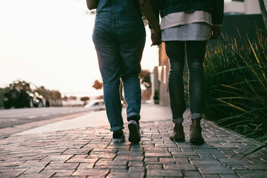 two people walking on the pavement during daytime